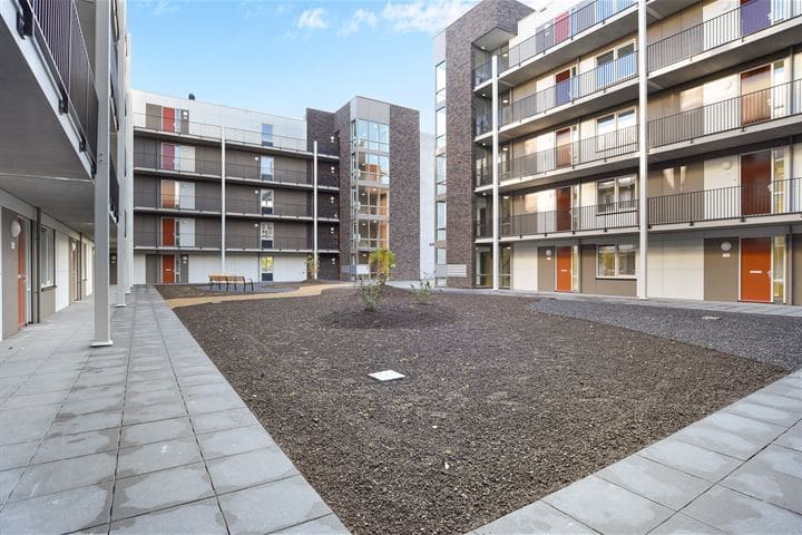 De binnenplaats van Waterburcht W3 met galerijen rondom en een grindvlak.