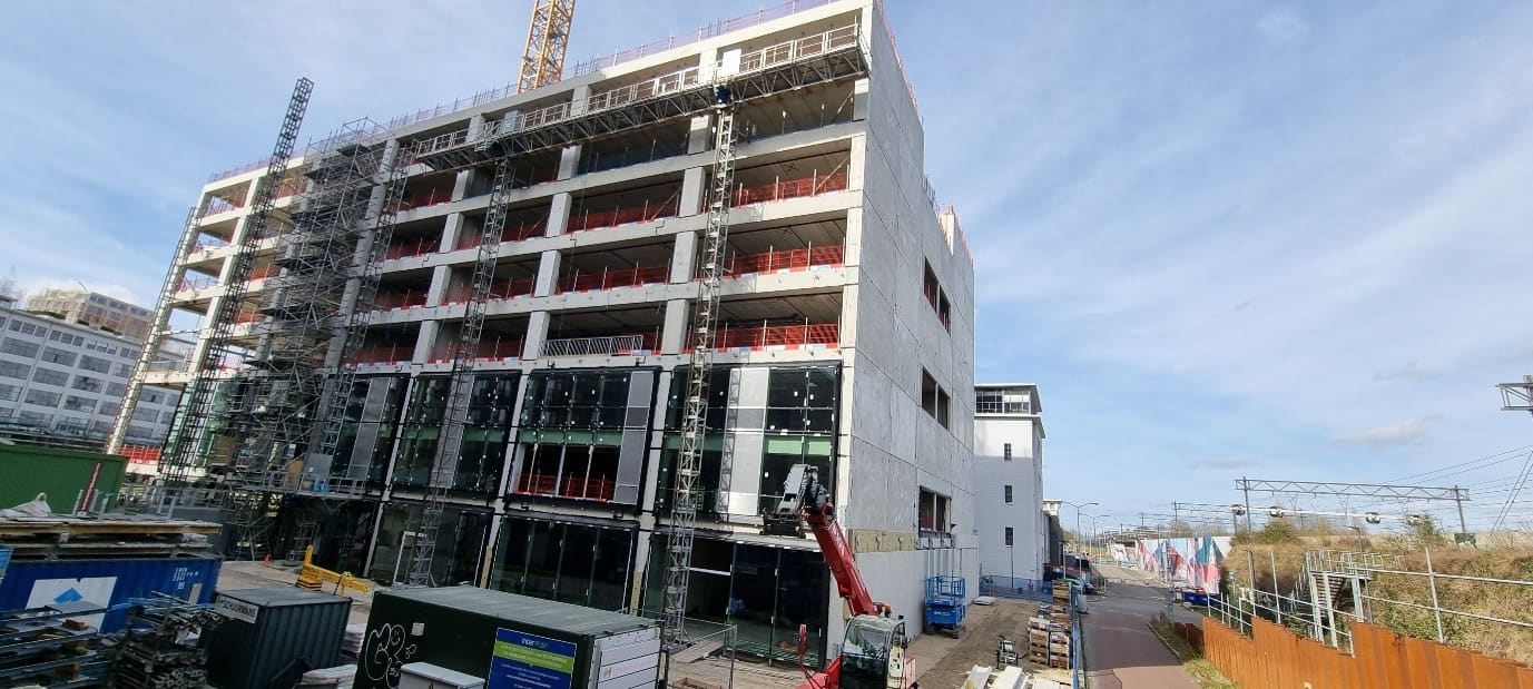 Gebouw DONNA in aanbouw, met steigers en de eerste gevelpanelen.