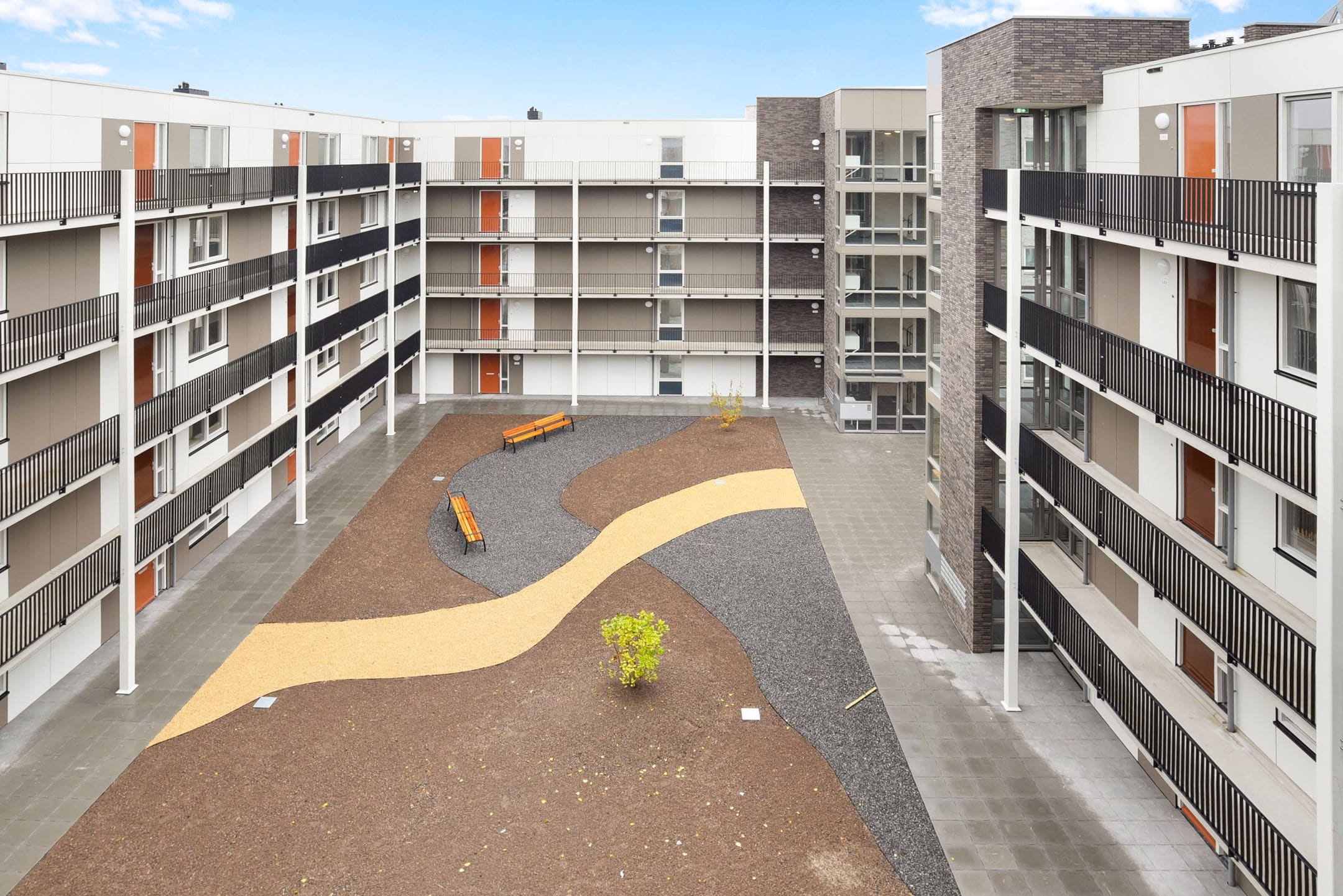 De binnenplaats met galerijen en een slingerend pad.